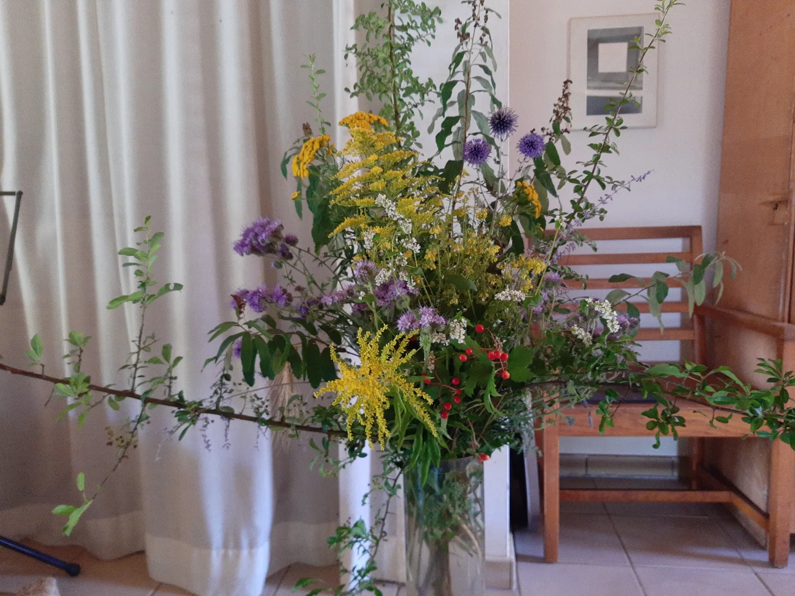 Luchtig veldboeket met wilde bloemen bij het raam