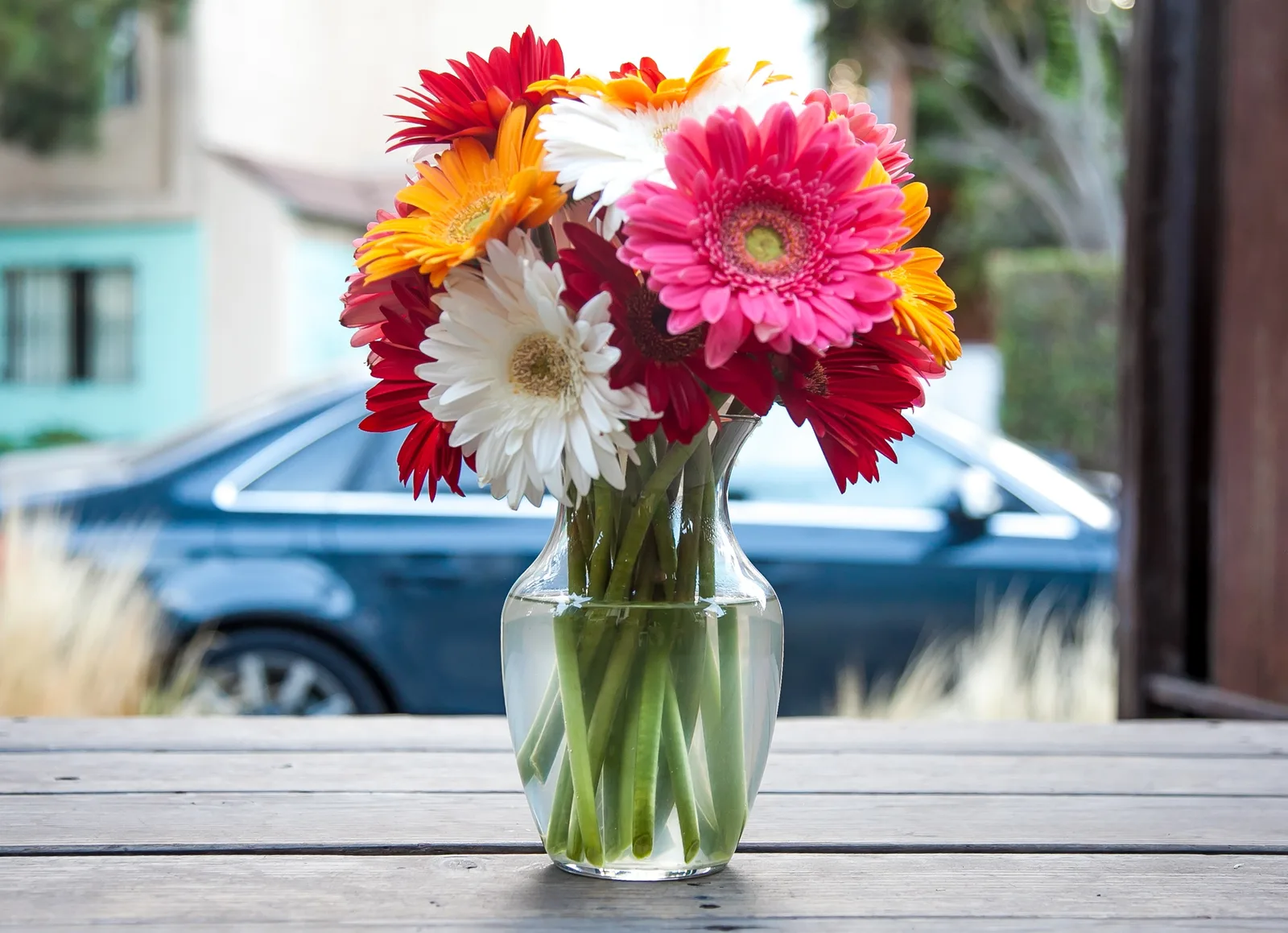 Vol gemengd boeket met gerberas in een glazen vaas