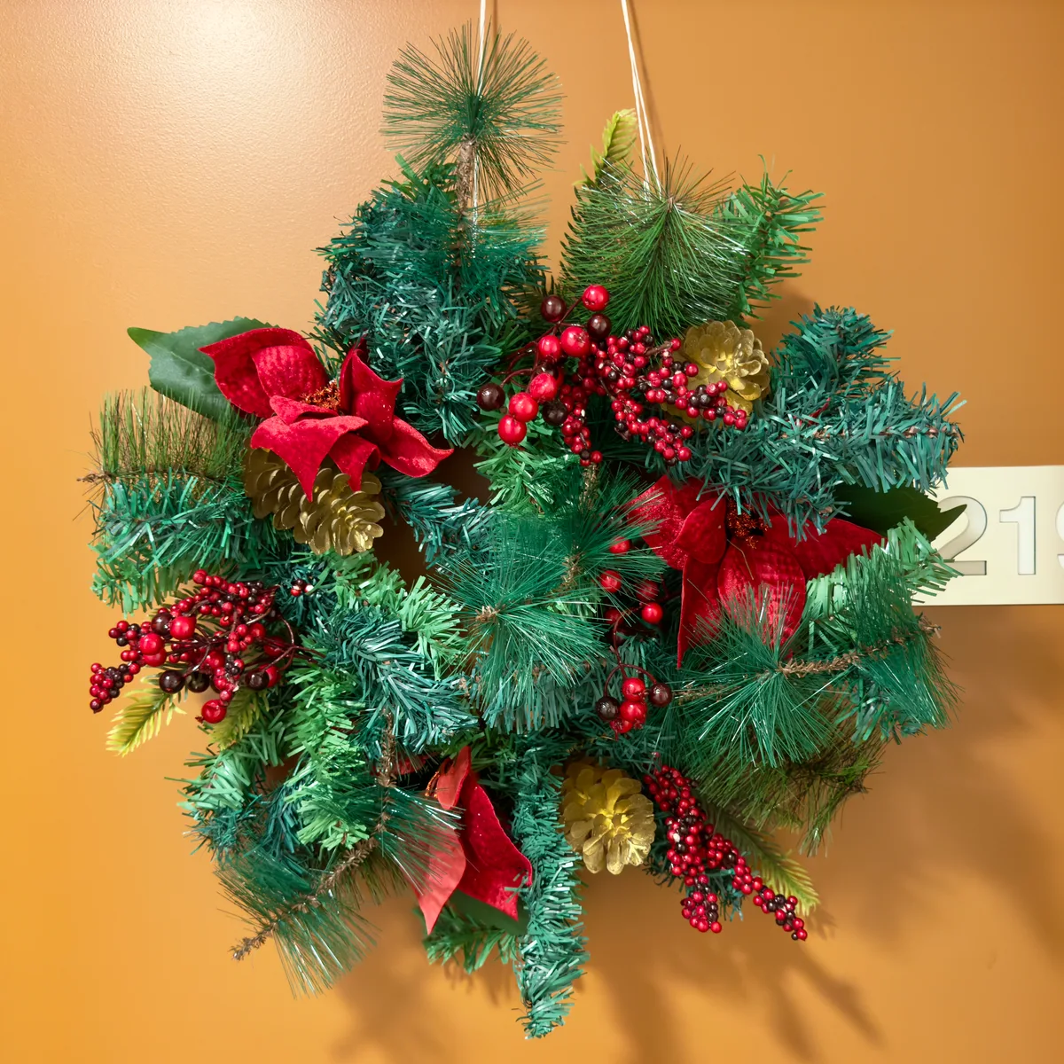 Groene kerstkrans met rode kerstster aan de deur