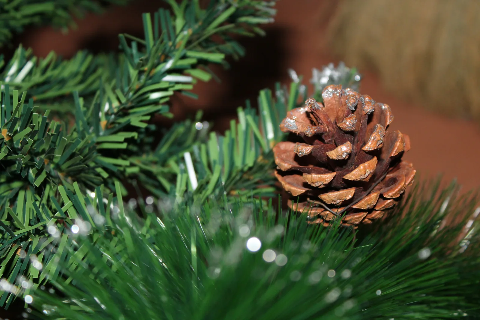Dennenappel op een dennentak met kerstdecoratie