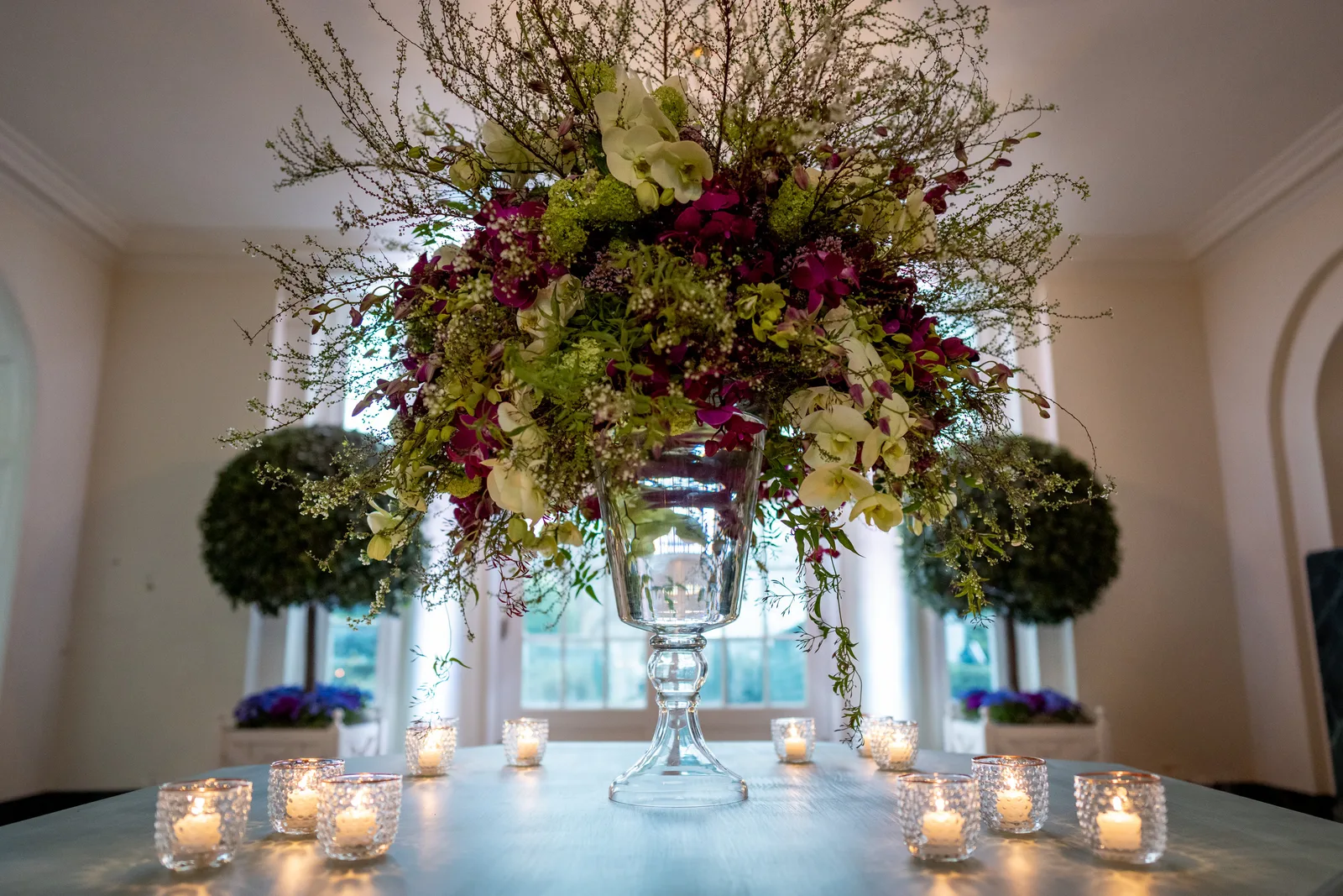 Elegant hoog tafelstuk met kaarsen op een gedekte tafel